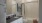 bathroom with a large mirror, tub and toilet